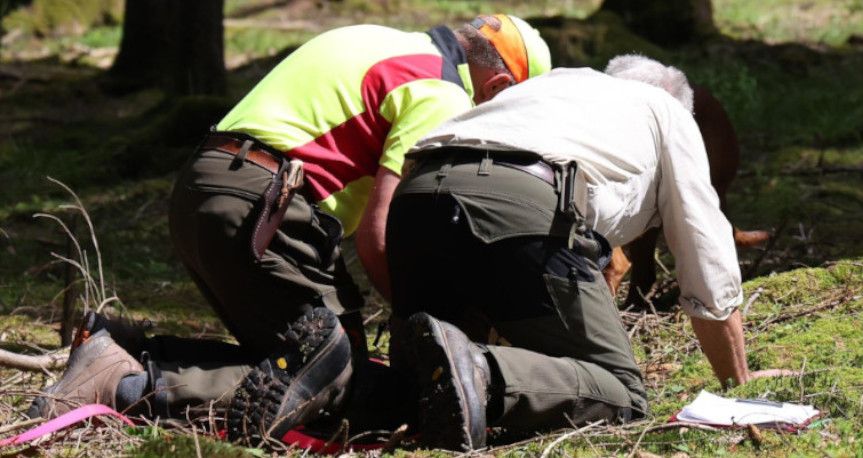 2 Seminarteilnehmer im Wald knieend